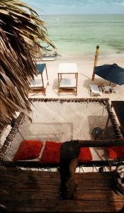 a view of a beach with chairs and an umbrella at Hostal Ananda in Playa Blanca +13 photos