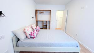 una camera da letto con un letto con cuscini sopra di Vizinho -Central - perto praia - Wi-Fi a Setúbal