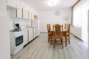 a kitchen with a table and chairs and white appliances at Apartments with parking space Lipovaca, Plitvice - 17657 in Rakovica