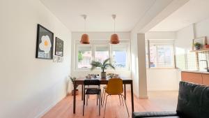 una sala da pranzo con tavolo e sedie di Vizinho -Central - perto praia - Wi-Fi a Setúbal