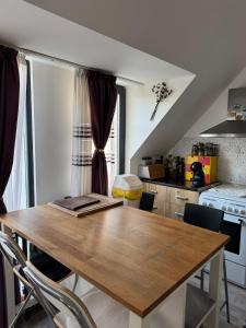 ヴァルナ・シティにあるHarbour Top-View Terrace 2-BDR Central Apartmentの木製のテーブルと椅子のあるキッチン