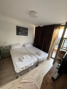 ヴァルナ・シティにあるHarbour Top-View Terrace 2-BDR Central Apartmentのベッドが2つと窓があるホテルの部屋