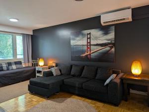 a living room with a couch and a painting of the golden gate bridge at Nice and spacious apartment in center - own carport and private sauna in Rauma