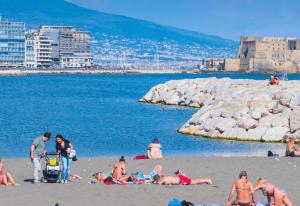a group of people laying on the beach at Talamo Room Boutique in Naples