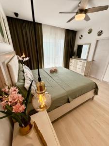 Las LagunasにあるTropical Escape with 3 Pools & Private Beach Club Aqua Esmeraldaのベッドと天井扇風機のある寝室