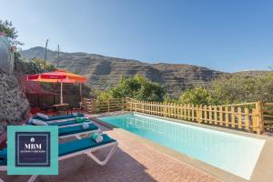 a resort with a swimming pool with mountains in the background at Casa Lolita, Valsequillo in Islas Canarias