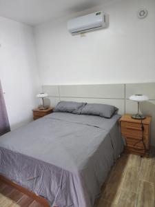 a bed in a room with two lamps and avertisement at Residencias crasky in Punta Cana