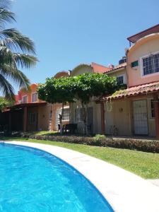 a swimming pool in front of a house at Casa en Ixtapa 3 recamaras con alberca in Ixtapa