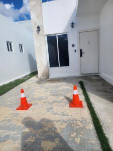 two orange traffic cones in front of a building at Residencias crasky in Punta Cana