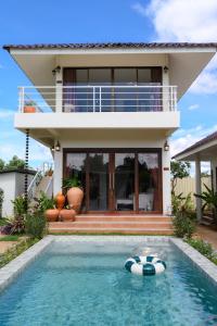 a house with a swimming pool in front of a house at Bougainvilla82 Kanchanaburi in Ban Nong Hoi