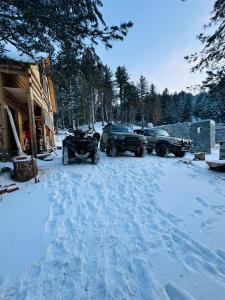 two atvs parked in the snow next to a house at Aleos cabin in Kolgecaj