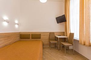 Pokój z krzesłami, stołem i telewizorem w obiekcie Mini Smart Apartments on Shpytalna 13- Economy Apartment w Lwowie