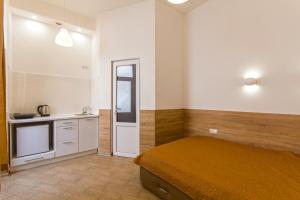 リヴィウにあるMini Smart Apartments on Shpytalna 13- Economy Apartmentのベッドルーム1室(ベッド1台付)、小さなキッチンが備わります。