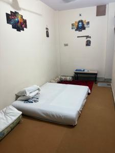 a room with two beds and a table in it at Pankali niwas in Varanasi