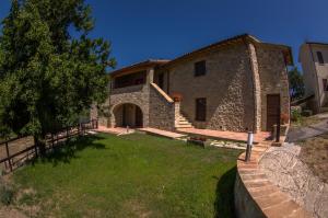 una grande casa in pietra con un cortile davanti di Borgo Buciardella a Baschi