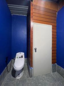 a bathroom with a toilet and a blue wall at Lamai Home 3 in Ko Yao Noi