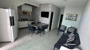 a kitchen with a table and chairs and a refrigerator at Casa do Airton in Icapuí
