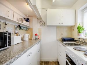 a kitchen with white cabinets and a counter top at Sandy Toes in Hunstanton