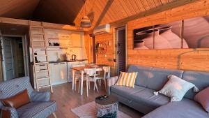 a living room with a couch and a table and a kitchen at Osada nad Zalewem in Tolkmicko