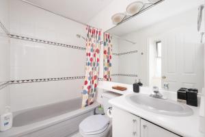a white bathroom with a sink and a toilet at Spacious Room with Private Washroom in Homestay in Vancouver