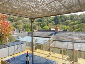 a view of a building from a patio with a bottle of wine at Snowdrop Cottage in Fishguard +4 photos