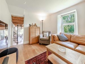 una sala de estar con un sofá y una mesa en Tan Y Castell Cottage - Llanmill, en Lampeter-Velfrey