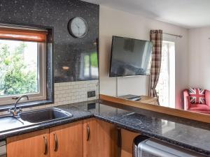 a kitchen with a sink and a clock on the wall at Rosedean in Ireby
