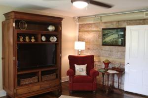 a living room with a tv and a red chair at The Hutch in Bardstown