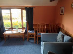a living room with a couch and a table and chairs at Stable Cottages in Cowes