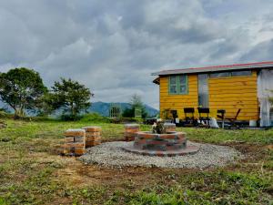 a yellow house with a fire pit in front of it at Cabaña Rustica Durango in Salento +39 photos