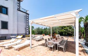 a white pergola on a patio with a table and chairs at Nice Home In Giffoni Sei Casali in Giffoni Sei Casali