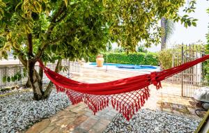 a red hammock hanging from a tree in a garden at Nice Home In Giffoni Sei Casali in Giffoni Sei Casali +41 photos