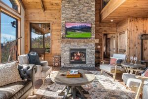a living room with a fireplace and a tv at Ridgetop Cabin Retreat w Pool Hot tub & Theater in Sevierville