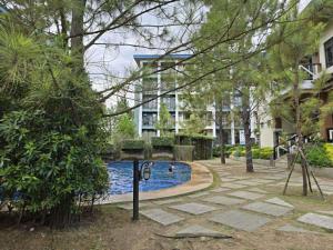 a swimming pool in a park next to a building at 2BR FAMILY AFFORD STAYCATION TAGAYTAy in Tagaytay