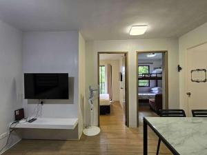 a living room with a television and a room with a couch at 2BR FAMILY AFFORD STAYCATION TAGAYTAy in Tagaytay