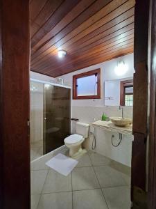 a bathroom with a toilet and a shower and a sink at Condomínio Valls Village in Itacaré