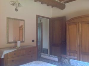 1 dormitorio con tocador y espejo en Agriturismo Dolce Verde, en Castiglione del Lago