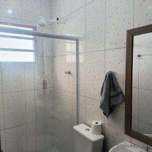 a bathroom with a shower and a toilet and a mirror at Apartamento em Santana de Parnaiba in Santana de Parnaíba