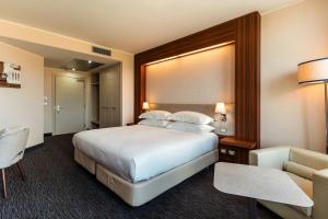 una habitación de hotel con una cama y una silla en Delta Hotels by Marriott Olbia Sardinia, en Olbia