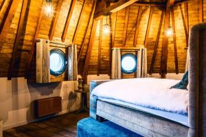a bedroom with two windows in a log cabin at De Gevangentoren Suite in Vlissingen