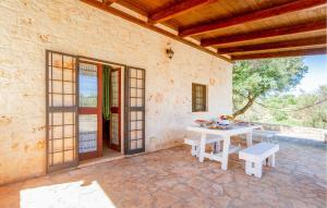 an outdoor patio with a white table and benches at Casale Valle Degli Ulivi in Ostuni +18 photos