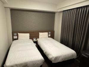 Dormy Inn Express Toyohashi客房内的一张或多张床位