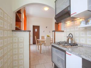 una cocina con estufa horno superior junto a una mesa en Your Private Garden Retreat, en Lucignano