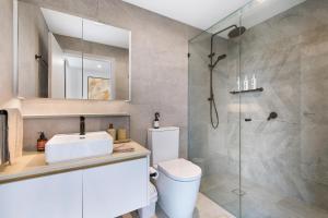 a bathroom with a shower and a toilet and a sink at Skyline Showdown - Views, Games & Vibes in Gold Coast +36 photos