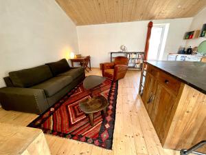 un soggiorno con un divano e un tavolo di Maison rénovée au cœur de Brem, 4 couchages, jardin, WIFI - FR-1-231-340 a Brem-sur-Mer