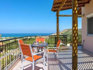 a table and chairs on a balcony with a view of the ocean at Holiday home, Marathokefala near Kolimbari in Marathokefála