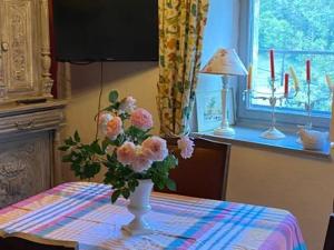 a vase of flowers sitting on top of a table at Maison de vigne charmante avec grande terrasse pour couple - FR-1-582-531 in Tailhac