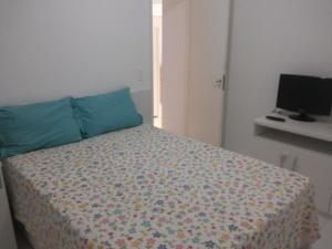 a bedroom with a bed and a computer on a desk at Apartamento Porto Real Brites in Mangaratiba +36 photos