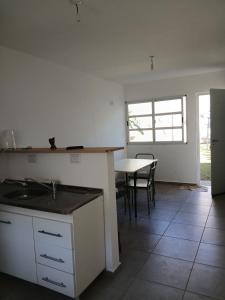 a kitchen with a sink and a table with chairs at La casa de Clo in Villa Carlos Paz +19 photos
