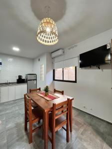 eine Küche mit einem Holztisch und Stühlen sowie einem Kronleuchter in der Unterkunft Complejo Entre Parras in San Rafael + 10 Fotos